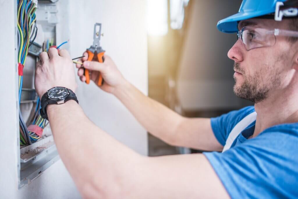 An electrician working with wires in an electrical box