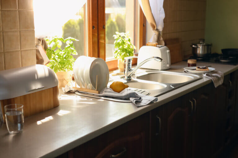 Countertop in the kitchen of a home with a deep sink, toaster, and breadbox