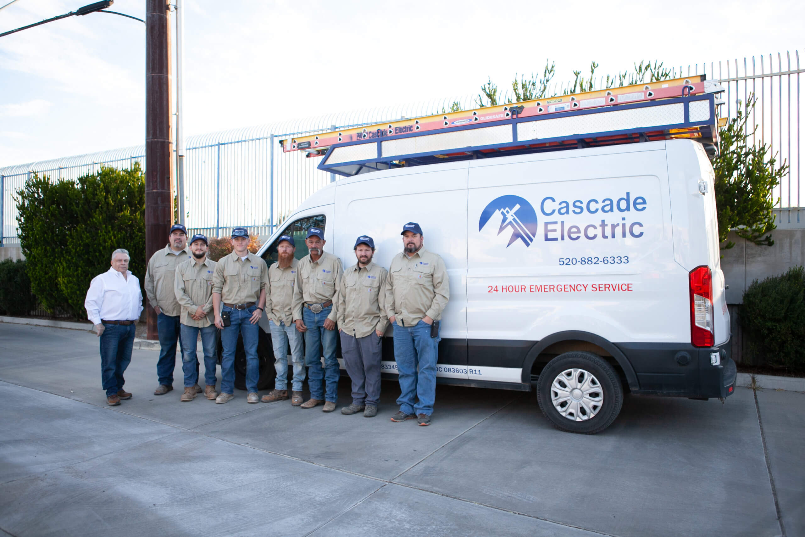 Team of 8 electricians standing in front of a Cascade Electric truck