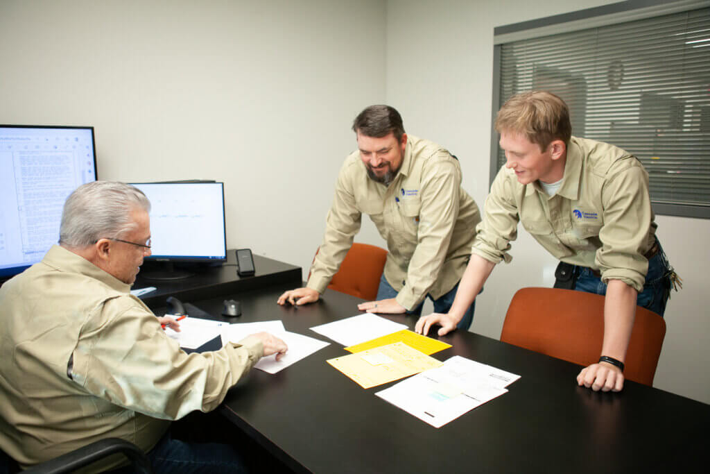 3 electricians reviewing plans for an electric installation project